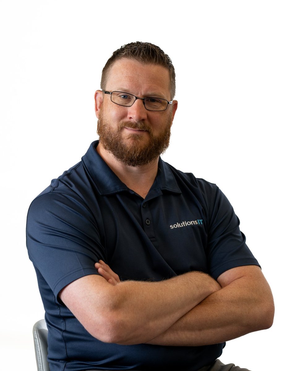 Randy, who leads Foresight Security, in a SolutionsIT polo with his arms crossed.